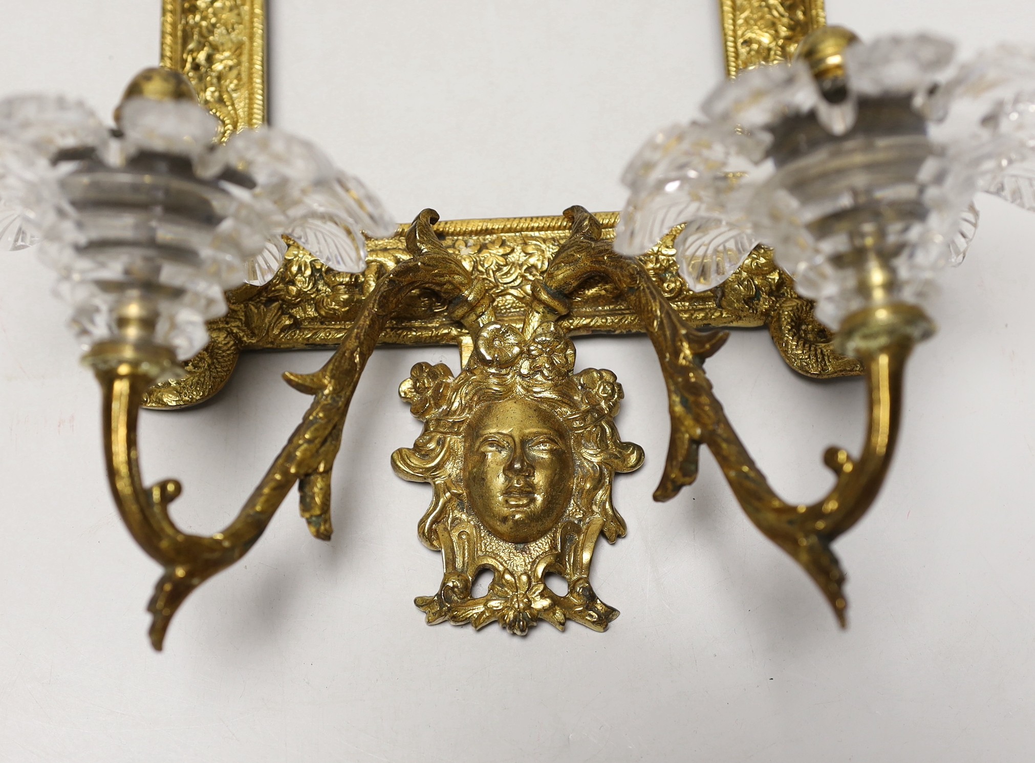 A decorative two branch ormolu wall mirror, lacking the mirror inset. 39cm tall overall, 16.5 x 11.5cm